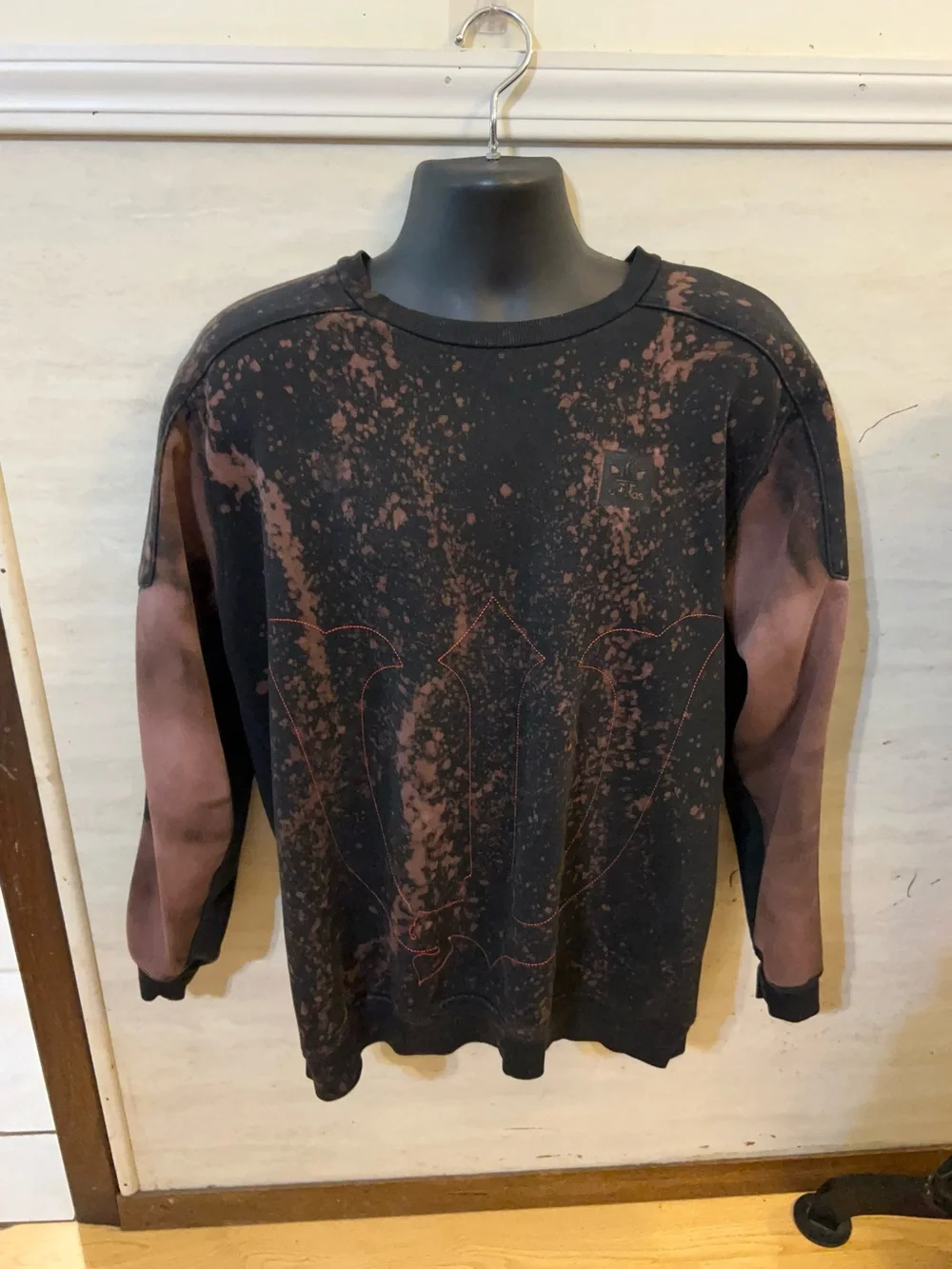 A upcycled, custom bleach-splattered Adidas crewneck sweatshirt